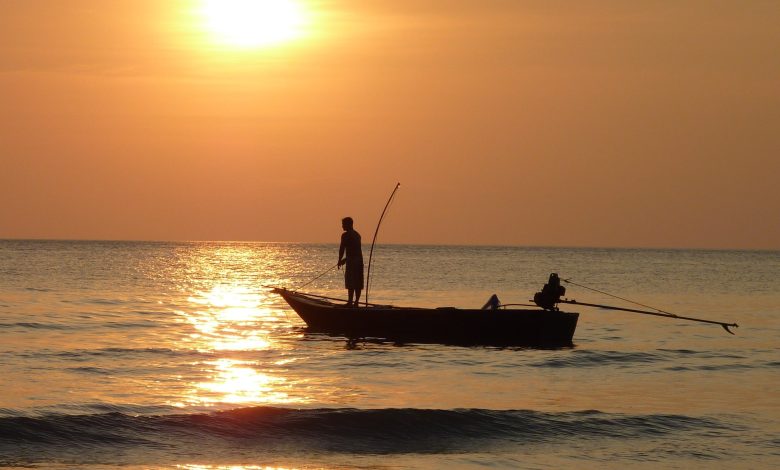 مردی ماهیگیر بر روی قایق در دریا